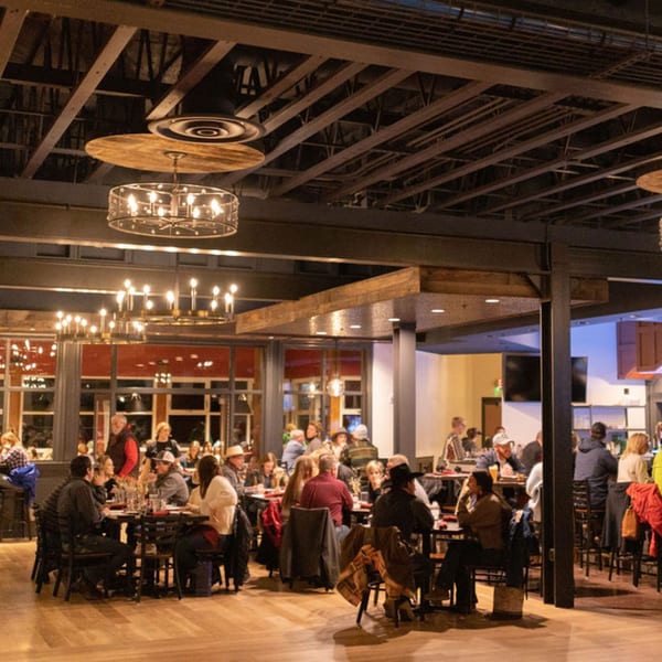 Diners enjoying meals and drinks in the spacious, warmly lit interior of The Jump Restaurant & Bar.